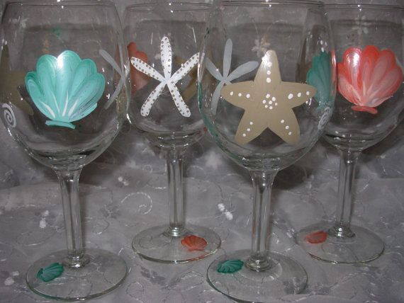 Two hand-painted wine glasses with beach-themed designs—seashells and starfish—created during a Wine glass paint & sip party.