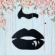 A bold pop-art style painting created during a Paint & Sip Party featuring black lips, a beauty mark, and cascading pastel roses forming a floral crown, with soft drips of color on a white background.