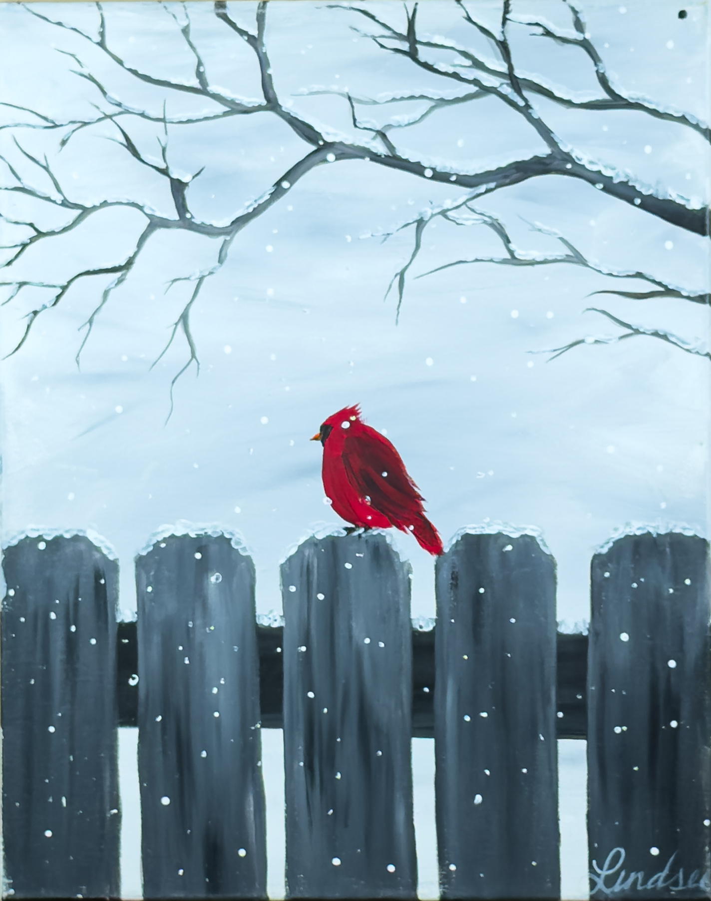 A red cardinal perched on a snowy wooden fence beneath winter branches – Wine & Canvas Toledo painting “Cardinal in the Snow”