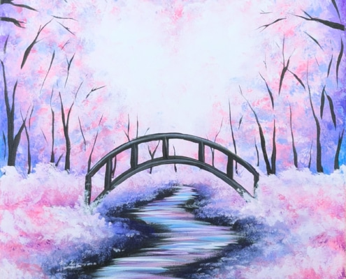 Pastel winter forest with a winding snowy path leading to a small arched bridge beneath pink and purple sunset skies
