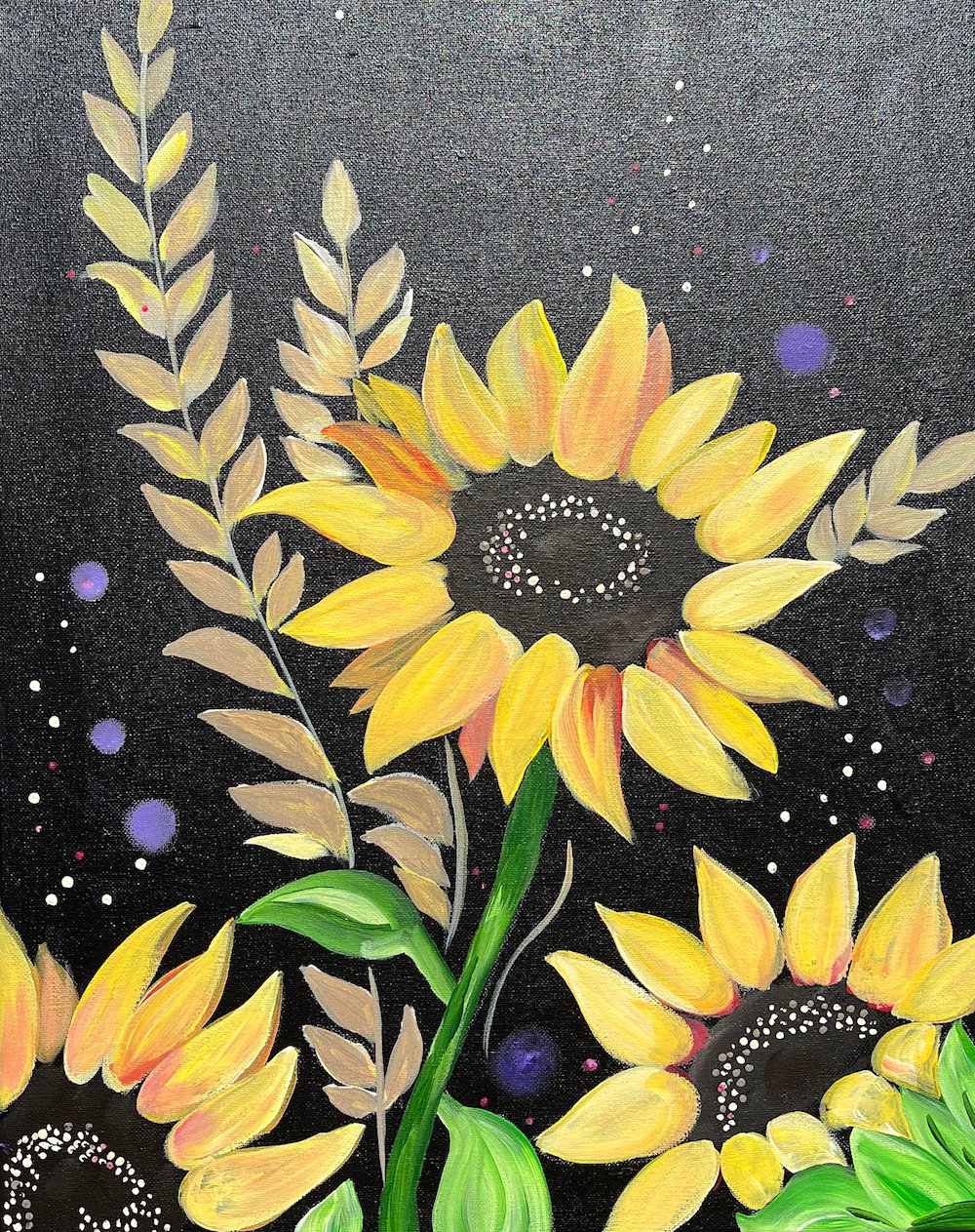 Bright yellow sunflowers painted on a black canvas with soft botanical accents and colorful speckled details surrounding the blooms.