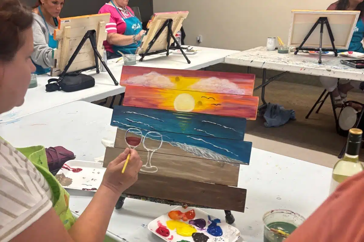 Guest painting a custom wood pallet during a specialty event